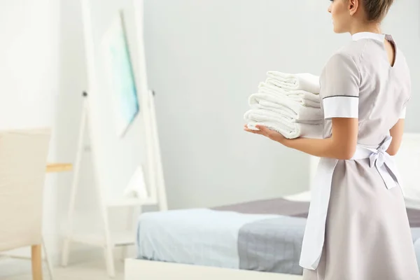 Chambermaid holding pile of clean towels — Stock Photo, Image