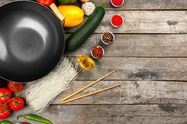 Wok avec des produits et des bâtons — Photo