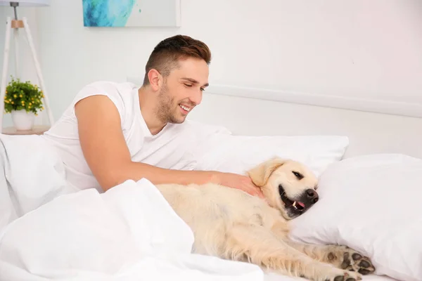 Homme couché avec Labrador retriever — Photo