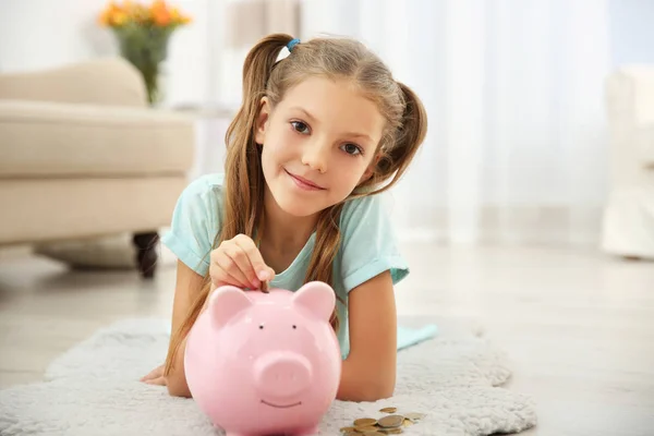 Cute Girl Putting Coins Piggy Bank Home — Stock Photo, Image