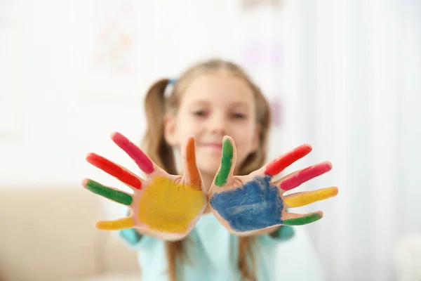 Cute girl with palms in paint — Stock Photo, Image