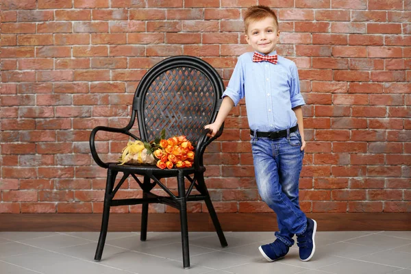 Niño y silla con ramo de hermosas flores — Foto de Stock