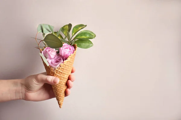 Рука тримає вафельний конус з квітами — стокове фото