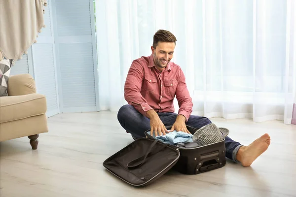 माणूस सूटकेस मध्ये कपडे ठेवणे — स्टॉक फोटो, इमेज