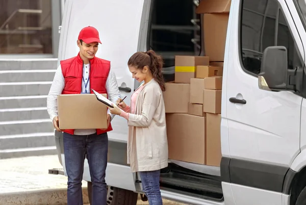 Junge Frau Unterschreibt Quittung Für Paketzustellung Von Männlichem Kurier — Stockfoto