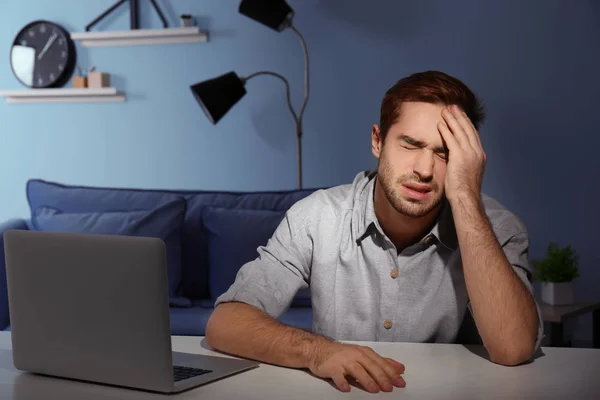 Dizüstü bilgisayar ile yorgun genç adam — Stok fotoğraf