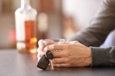 Oturan adam araba anahtarı ve cam çubuk 