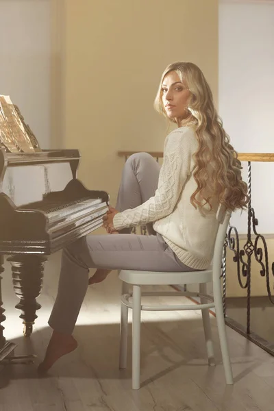 Mooie vrouw op piano — Stockfoto