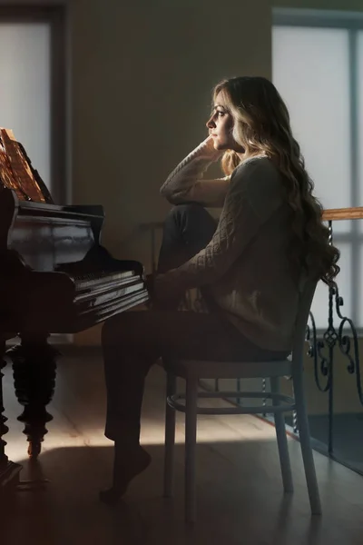 Vacker kvinna på piano — Stockfoto