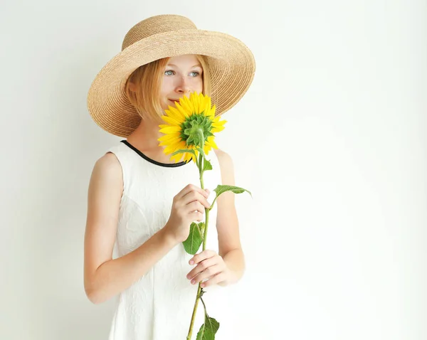 Meisje in stro hoed met zonnebloem — Stockfoto