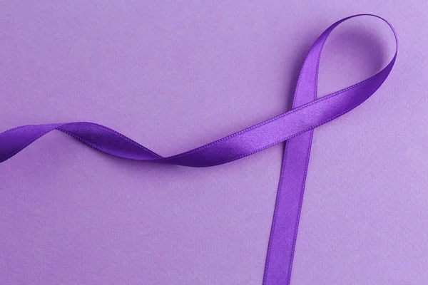 Violet ribbon on color background. — Stock Photo, Image