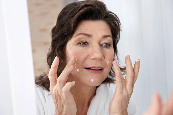 Seniorin Cremt Gesicht Vor Spiegel Ein Nahaufnahme — Stockfoto