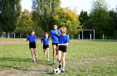 Futbol sahada oynayan sevimli çocuklar