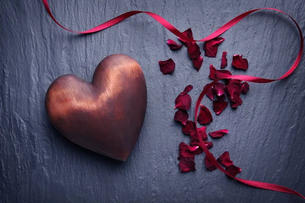 Corazón con pétalos de flores y cinta — Foto de Stock