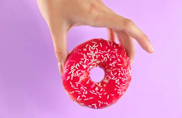 Weibliche Hand hält köstlichen Donut — Stockfoto