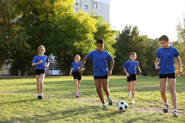 Futbol sahada oynayan sevimli çocuklar — Stok fotoğraf