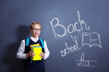 Sırt çantası ve okul blackboard duran kitaplar ile öğrenci