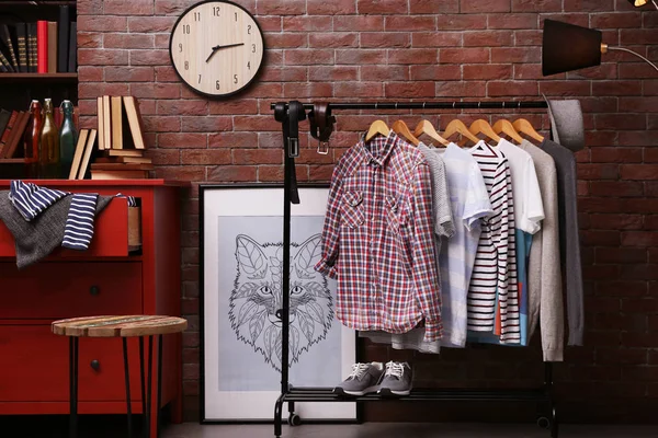 Casual stylish shirts on hanger stand in room — Stock Photo, Image