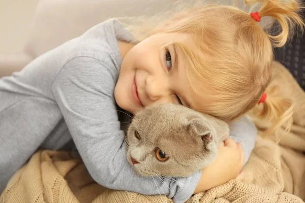 Niedliches kleines Mädchen umarmt Katze — Stockfoto
