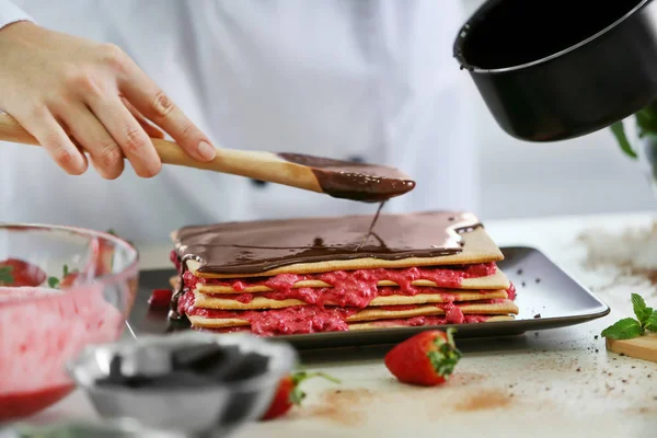 Pastelero profesional decorando delicioso pastel — Foto de Stock