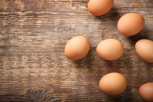 Surowe jaja na drewnianym stole — Zdjęcie stockowe