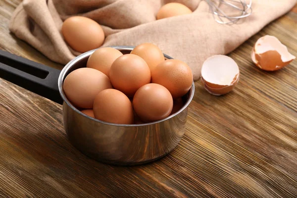 Raw eggs in saucepan — Stock Photo, Image