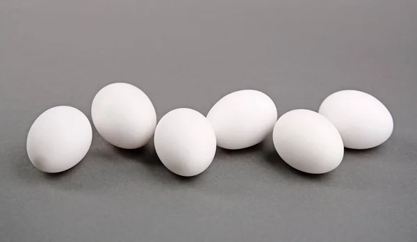 Witte eieren op grijs — Stockfoto