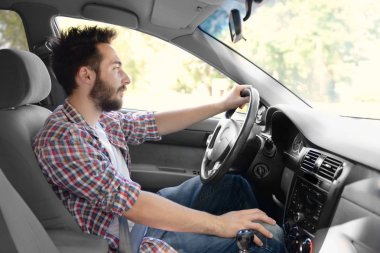 Genç adam araba kullanıyor.