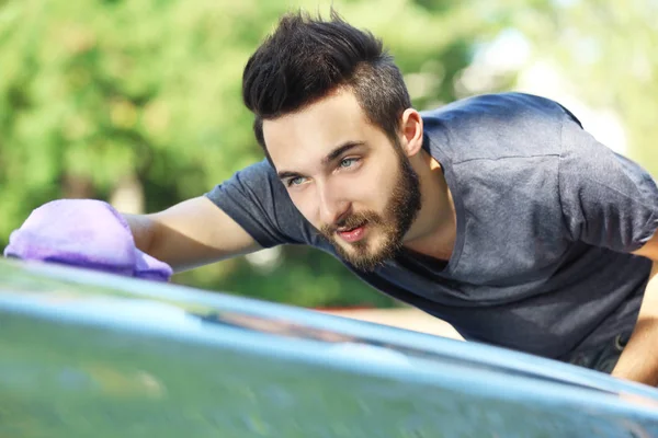 Joven hombre limpiando coche — Foto de Stock