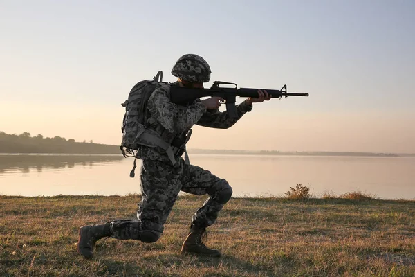 Silhouette Soldato Con Fucile Vicino Fiume Tramonto — Foto Stock