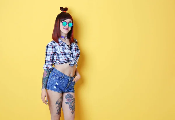 Menina bonita com tatuagem no fundo de cor — Fotografia de Stock