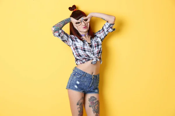 Mooi meisje met tatoeage op kleur achtergrond — Stockfoto