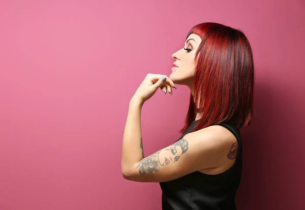 Hermosa chica con tatuaje en el fondo de color — Foto de Stock