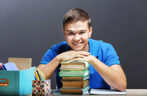 Estudante com livros sentados à mesa — Fotografia de Stock