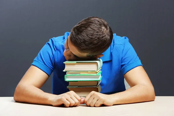 Estudiante con libros sentados a la mesa — Foto de Stock