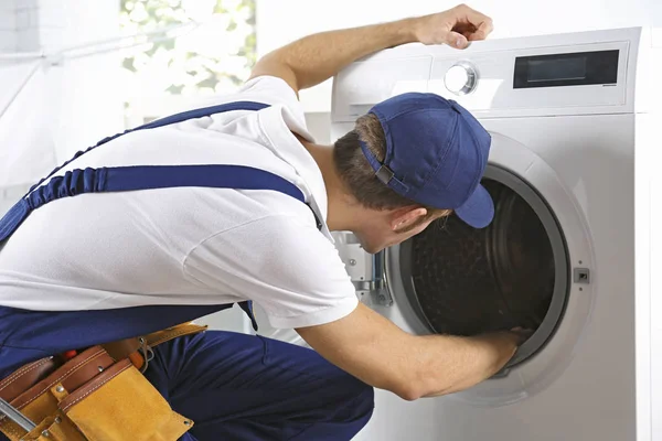 Plumber repairing washing machine — Stock Photo, Image