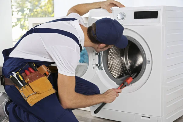 Plumber repairing washing machine — Stock Photo, Image