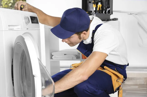 Plumber repairing washing machine — Stock Photo, Image