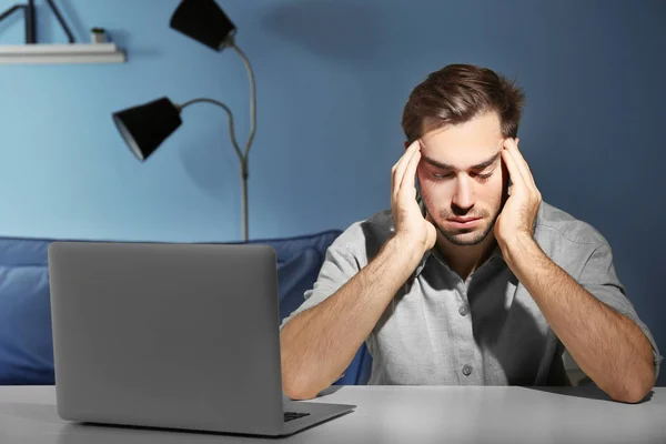 Joven cansado con portátil — Foto de Stock