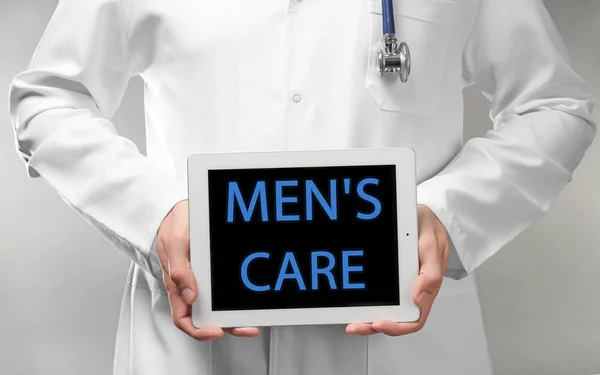 Läkare innehav tablett med text mäns omsorg — Stockfoto
