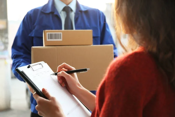 Mujer Joven Firmando Documentos Después Recibir Paquetes Mensajería Primer Plano —  Fotos de Stock