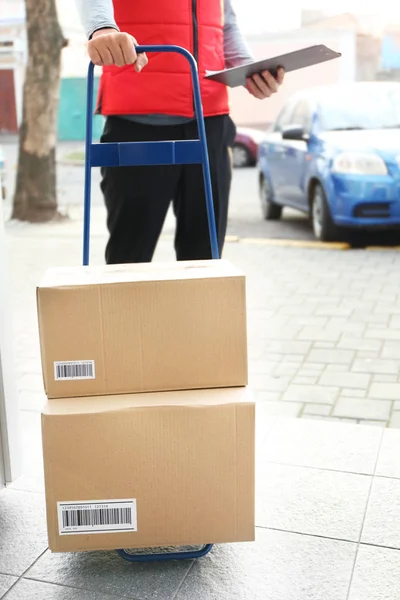 Courier holding cart with parcels — Stock Photo, Image