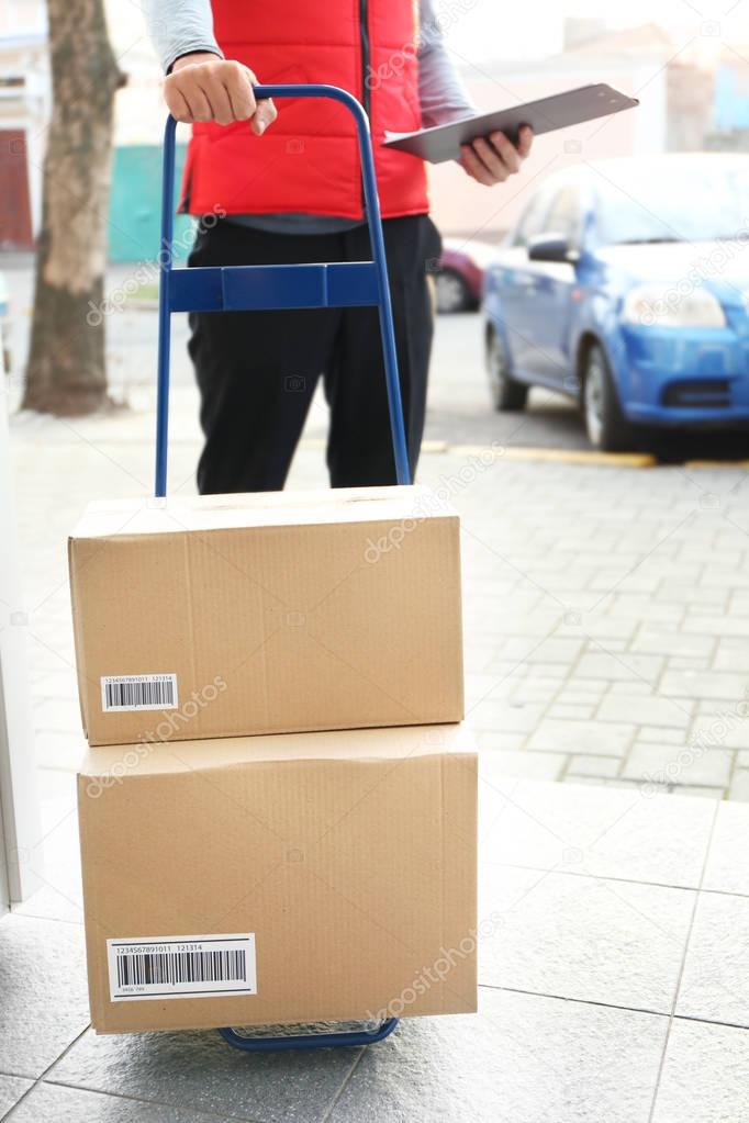 Courier holding cart with parcels