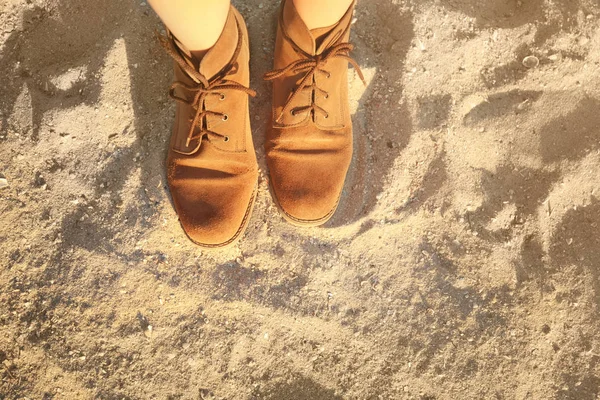 Feet in shoes on sand