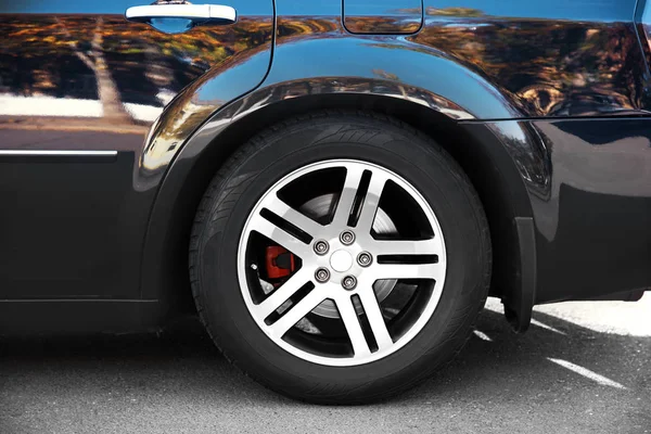 Wheel of luxury black car, closeup — Stock Photo, Image