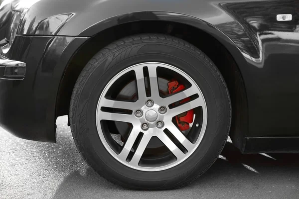Wheel of luxury black car, closeup — Stock Photo, Image