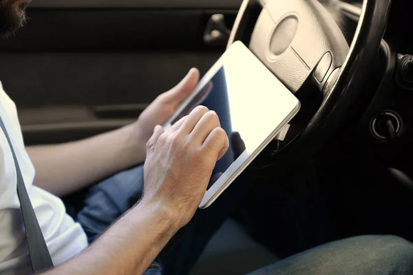 Young male driver using tablet computer