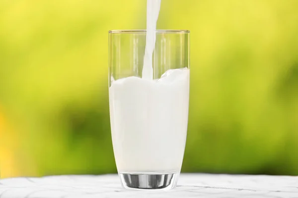 Milch ins Glas gießen — Stockfoto