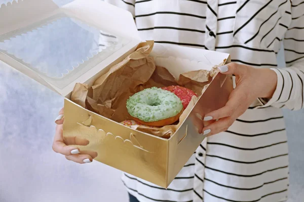 Vrouw bedrijf doos met donuts — Stockfoto