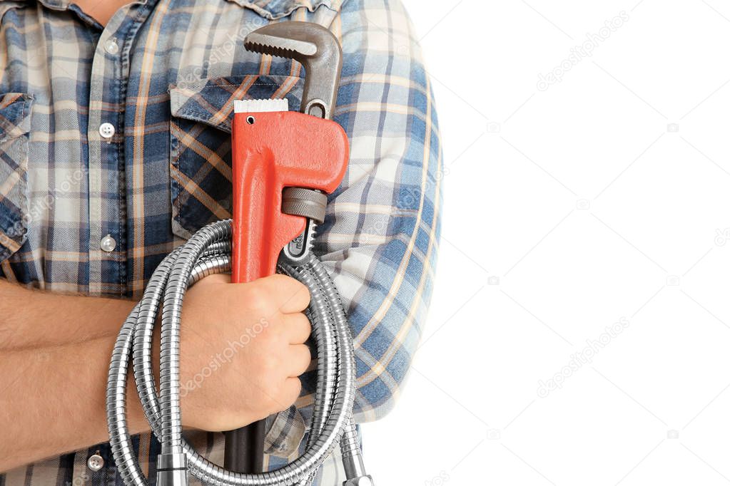 Man with pipe wrench and flexible hose